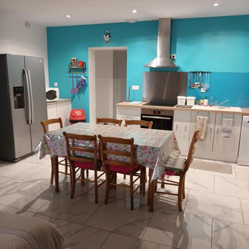 a kitchen with a table with chairs and a refrigerator at La petite maison Lavandin 