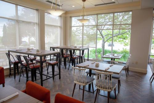 a restaurant with tables and chairs and large windows at Hilton Garden Inn Temple Medical Center in Temple
