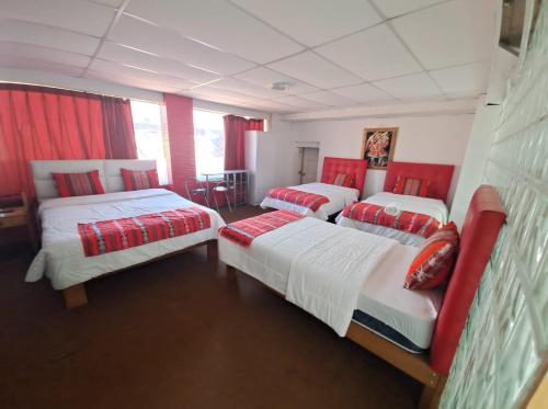 three beds in a room with red curtains at Hotel Plateros in Cusco