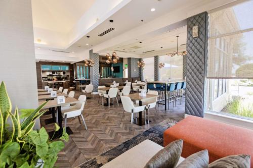 a restaurant with tables and chairs and a bar at Hilton Garden Inn Temple Medical Center in Temple