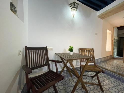 two chairs and a table in a room at Dar Sunrise Fes in Fès
