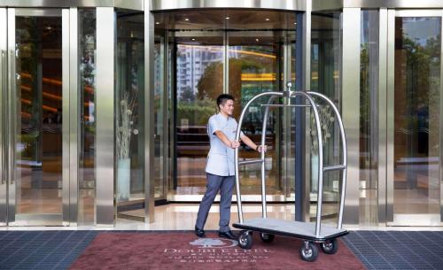 a man standing in front of a building with a scooter at DoubleTree by Hilton Hotel Xiamen - Wuyuan Bay in Xiamen