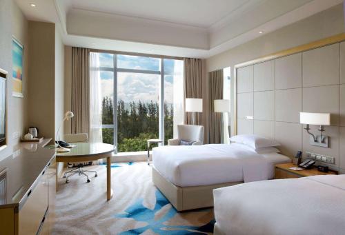 DoubleTree by Hilton Hotel Xiamen - Wuyuan Bay في شيامن: غرفة فندقية بسريرين ومكتب