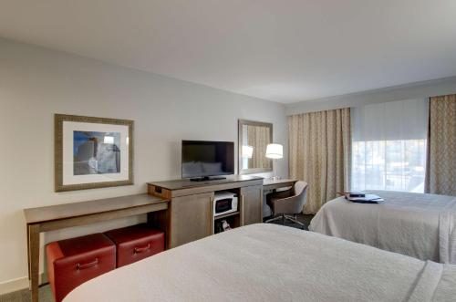 a hotel room with two beds and a flat screen tv at Hampton Inn & Suites Springfield Downtown in Springfield