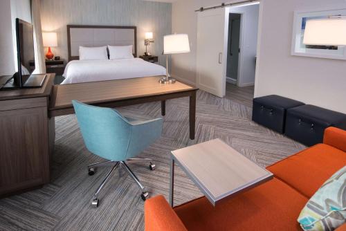 a hotel room with a bed and a desk and a couch at Chateau Fredericton, Trademark Collection by Wyndham in Fredericton