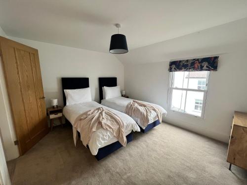 a bedroom with two beds and a window at Modern Townhouse in the heart of Beaumaris in Beaumaris