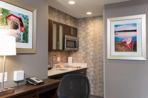 a kitchen with a desk and a chair in a room at Homewood Suites by Hilton Cleveland/Sheffield in Avon