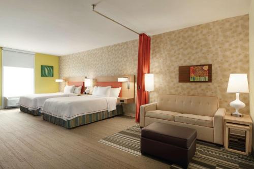 une chambre d'hôtel avec deux lits et un canapé dans l'établissement Home2 Suites by Hilton Cartersville, à Cartersville