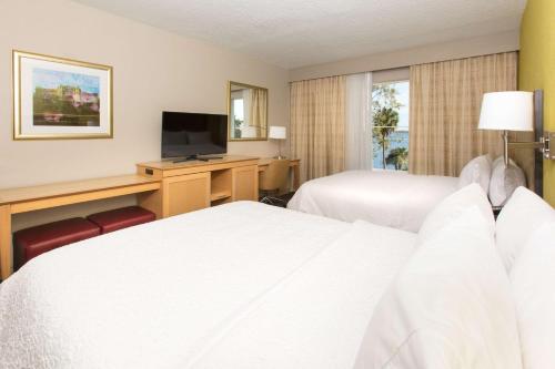 a hotel room with two beds and a television at Hampton Inn - Palatka in Palatka