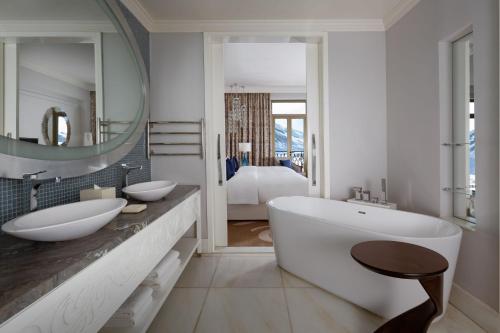 a bathroom with two sinks and a large mirror at Pik Palace, Shahdag, Autograph Collection in Shahdag