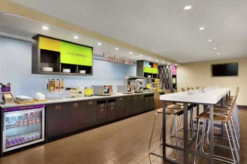 a kitchen with a counter and a bar with stools at Home2 Suites By Hilton Macon I-75 North in Macon