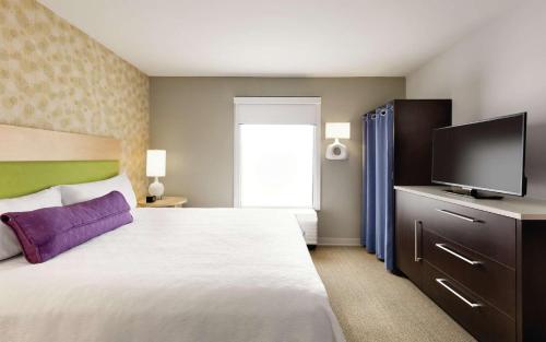 a bedroom with a large bed and a flat screen tv at Home2 Suites By Hilton Macon I-75 North in Macon