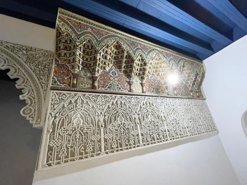 a mosaic wall in a room with a blue ceiling at Dar Sunrise Fes in Fès