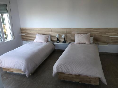 two beds sitting next to each other in a room at Casa tranquila in Teulada