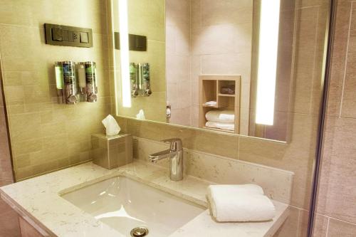 هامبتون باي هيلتون بولو في بولو: حمام مع حوض ومرآة