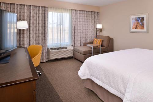 une chambre d'hôtel avec un lit et une chaise dans l'établissement Hampton Inn El Centro, à El Centro