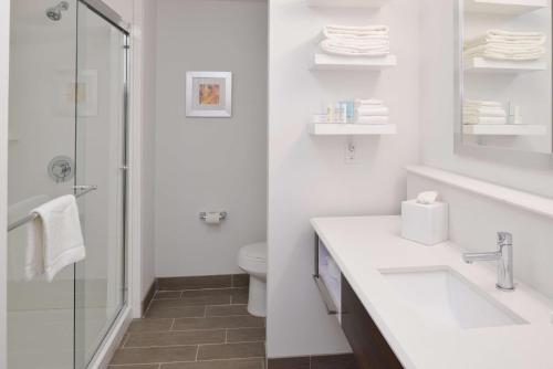 La salle de bains blanche est pourvue d'un lavabo et d'une douche. dans l'établissement Hampton Inn El Centro, à El Centro