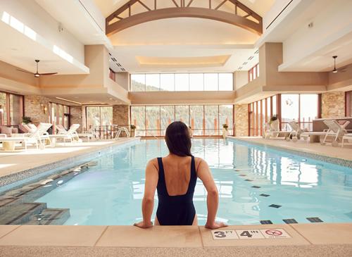 uma mulher sentada em frente a uma piscina em Monarch Casino Resort Spa em Black Hawk