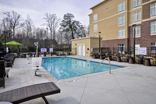 a pool at a hotel with chairs and a building at Homewood Suites By Hilton Augusta Gordon Highway in Augusta