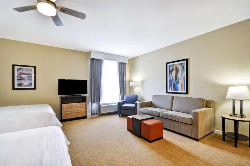 a hotel room with a bed and a couch and a tv at Homewood Suites By Hilton Augusta Gordon Highway in Augusta