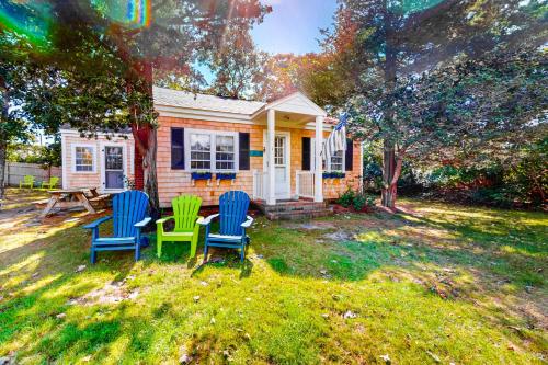 a house with three chairs and a table in the yard at The Spray in Harwich Port
