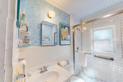 baño blanco con lavabo y ventana en The Spray en Harwich Port