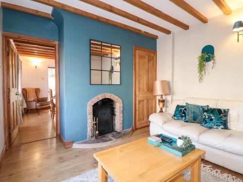 a living room with a white couch and a fireplace at The Old Sweet Shop in Melton Mowbray