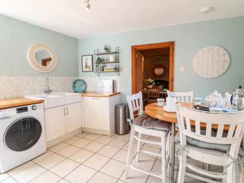 een keuken met een tafel en een wasmachine bij The Old Sweet Shop in Melton Mowbray