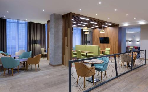 a restaurant with tables and chairs in a lobby at Hampton By Hilton Astana Triumphal Arch in Astana