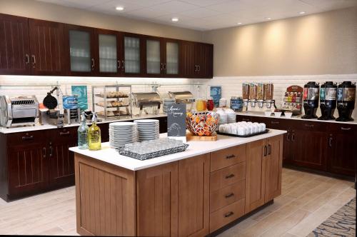 a large kitchen with a counter with dishes on it at Homewood Suites By Hilton West Fargo/Sanford Medical Center in Fargo