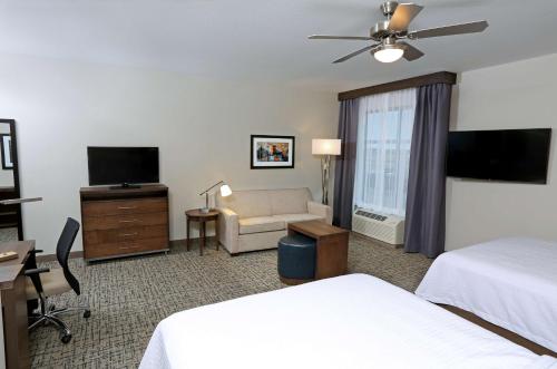a hotel room with two beds and a television at Homewood Suites By Hilton West Fargo/Sanford Medical Center in Fargo