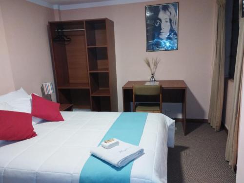 a hotel room with a bed and a desk and a desk at Huaytusive Inn Hotel in Puno