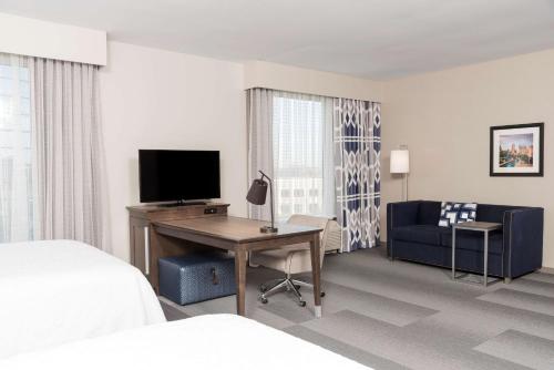 a hotel room with a bed and a desk with a television at Hampton Inn & Suites Indianapolis-Keystone, IN in Indianapolis