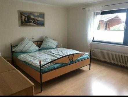 - une chambre avec un lit dans une pièce dotée d'une fenêtre dans l'établissement Am Mühlenberg, 