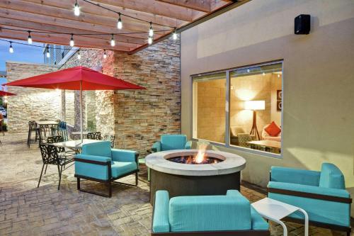 a patio with a fire pit and chairs and a table at Home2 Suites by Hilton Springfield North in Springfield