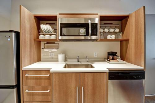 a kitchen with a sink and a microwave at Home2 Suites by Hilton Springfield North in Springfield