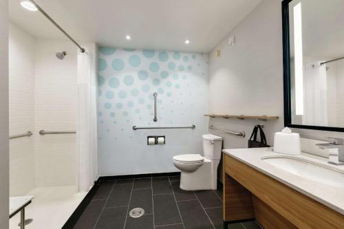 a bathroom with a toilet and a sink and a tub at Tru By Hilton Charlotte Ayrsley in Charlotte