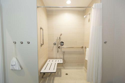 a white shower with a bench in a bathroom at Hampton Inn Mustang in Mustang