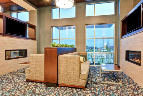a lobby with two chairs and large windows at Embassy Suites By Hilton Plainfield Indianapolis Airport in Plainfield