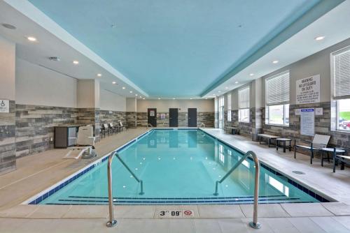 a large swimming pool in a hotel lobby with a large pool at Embassy Suites By Hilton Plainfield Indianapolis Airport in Plainfield