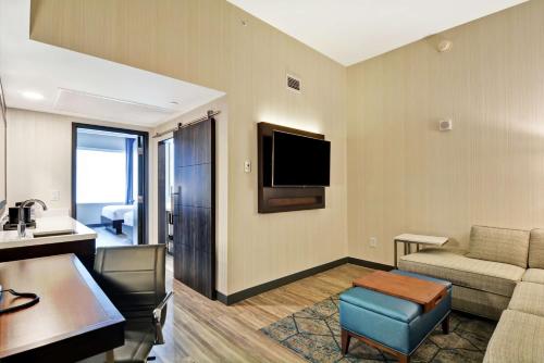 a living room with a couch and a tv at Embassy Suites By Hilton Plainfield Indianapolis Airport in Plainfield