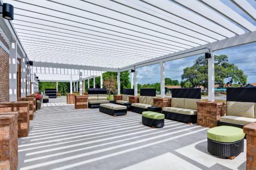 a patio with couches and chairs under a pergola at Home2 Suites By Hilton Beaufort in Beaufort