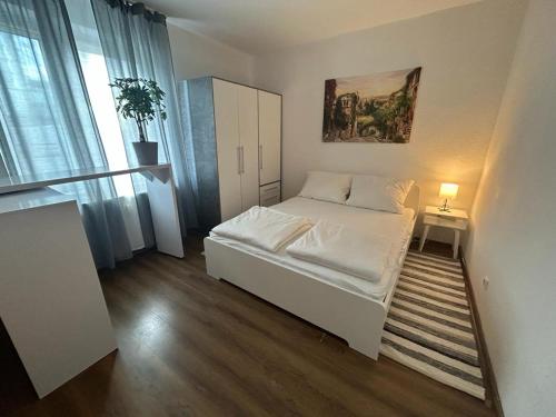a small bedroom with a white bed and a window at SkyLineApartment in Frankfurt/Main