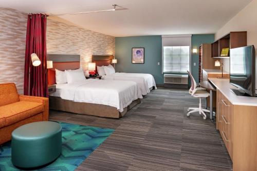 a hotel room with two beds and a couch at Home2 Suites By Hilton New Albany Columbus in New Albany