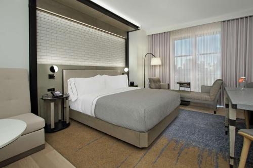 um quarto de hotel com uma cama e uma secretária em Canopy By Hilton Columbus Downtown Short North em Columbus