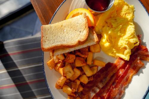 un plato de desayuno con huevos tocino y patatas fritas en Four Points Marriott Salt Lake City Airport en Salt Lake City