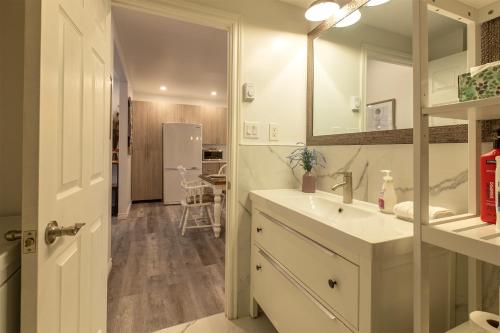 a bathroom with a sink and a mirror and a refrigerator at Cozy Condo 2BDR MTL Downtown- 4410 in Montreal