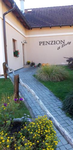 a sign on the side of a building with flowers at Penzion U Štoly in Úsilné