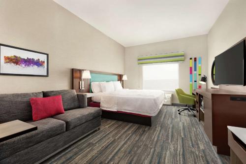 una camera d'albergo con letto e divano di Hampton Inn West Valley Salt Lake City a West Valley City