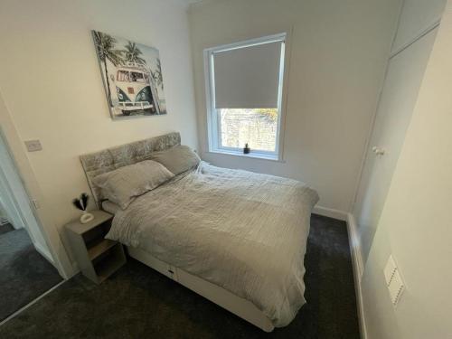 1 dormitorio con cama y ventana en 3 Bedroom House Brighouse en Brighouse